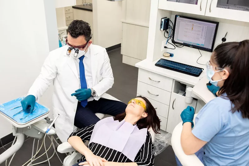 Dr. Bilus Poles and his assistant treating a patient at Omni Dental in Arlington Heights