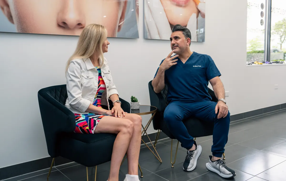 Dr. Bilus Poles talking with a patient in the consultation room at Omni Dental in Arlington Heights, IL