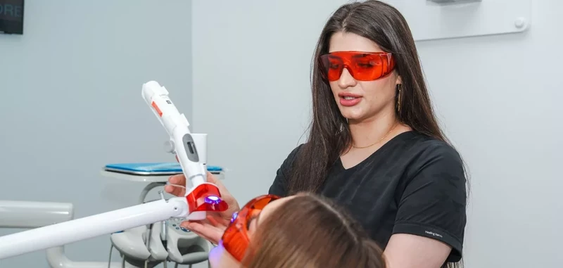 Teeth whitening at Omni Dental in Arlington Heights: a patient in protective glasses under a dental treatment light